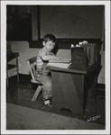 Young Patient with Book Sitting at Desk