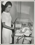Nurse Checking on Infant in Incubator