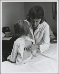 Nurse with Stethoscope Listening to Patient