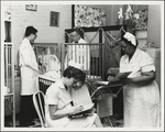 Nurses Charting While Doctors Check Infant Patient