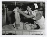 Nurse Adjusting Patient's Legs in Traction